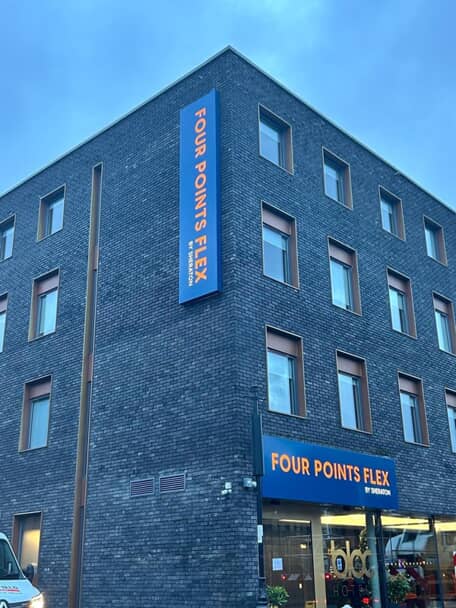 An image of the Four Points Flex exterior signage above the entrance and at the top of the multi-story building vertically.